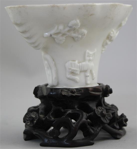 A Chinese Dehua blanc-de-chine libation cup, late 17th / early 18th century, 13cm, carved wood stand